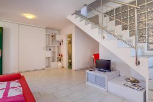a living room with a staircase and a television at apartman Nataša in Mali Lošinj