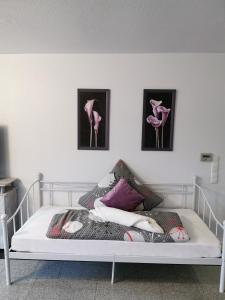 - une chambre dotée d'un lit avec 3 photos sur le mur dans l'établissement FeWo bis 8 Personen, à Wilhelmshaven