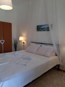 a bedroom with a large white bed with white sheets at Captain's Beauty & Wellness House in Stratónion