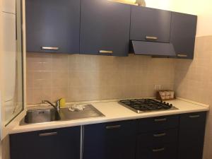 a kitchen with black cabinets and a sink and a stove at Platamona Villaggio Grigio in Sorso
