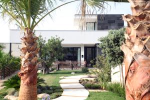 a garden with a palm tree and a walkway at Villa Pina in Bari
