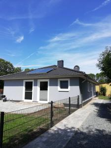 a white house with a black roof at Ferienhaus Gammendorf Nr. 18 in Fehmarn