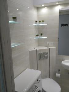 biała łazienka z toaletą i umywalką w obiekcie Apartament UnoPuro w centrum Giżycka w mieście Giżycko