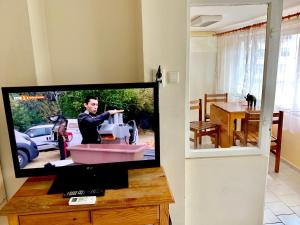a television in a living room with a man with a sewing machine at Jackie House Varna in Varna City