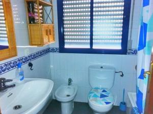 a bathroom with a white toilet and a sink at Apartamento y Parking en pleno CENTRO, DAMAS in Huelva