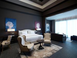 a bedroom with a large bed and a living room at Pelagos Suites Hotel & Spa in Kos