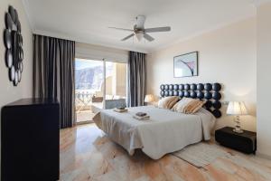 a bedroom with a large bed with a ceiling fan at Apartamento Ocean View in Puerto de Santiago +47 photos