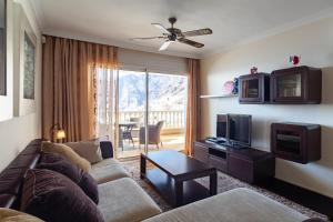 a living room with a couch and a tv at Apartamento Ocean View in Puerto de Santiago