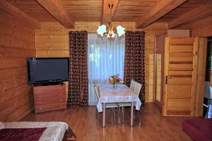 a dining room with a table and a flat screen tv at Jankówka in Wieliczka