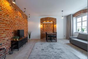 a living room with a couch and a brick wall at Stay99 in Poznań