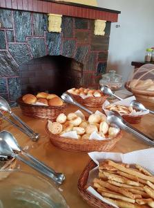 a table with baskets of bread and baskets of pastries at Hotel pousada & Eventos Cassino in Caeté