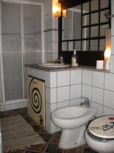 a bathroom with a toilet and a sink at La Gallina Felice B&B in Meta