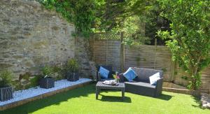 um jardim com um sofá e uma mesa na relva em Broad Park Villa em Ilfracombe
