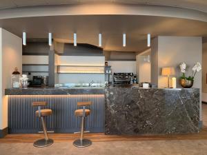 una grande cucina con bancone e sgabelli di DC HOTEL INTERNATIONAL a Padova