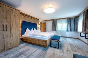 a bedroom with a large bed with a blue headboard at Das Stoaberg in Leogang +116 photos