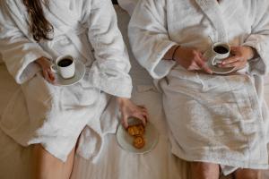 a woman in a white dress holding a cup of coffee at Emmantina Hotel in Athens