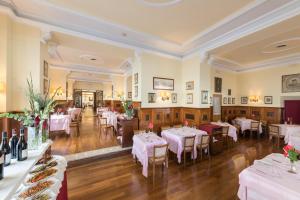 un ristorante con tavoli e sedie bianchi in una stanza di Bettoja Hotel Massimo d'Azeglio a Roma