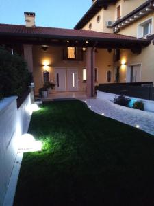 a lawn with lights in front of a house at Sotto il Portico Home in Tezze sul Brenta