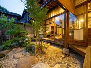 una casa con un jardín delante de ella en Inase Otsu Machiya Bed and Breakfast, en Otsu