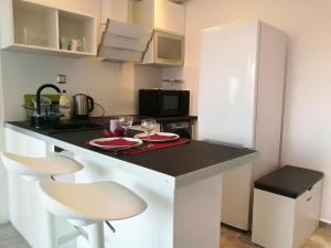 a kitchen with a counter with two chairs and a table at Apartments 4 You in Wrocław