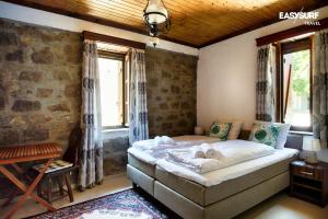 1 dormitorio con 1 cama en una habitación con ventanas en Stone House Limnos en Repanídhion