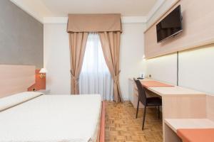 a hotel room with a bed and a desk and a television at Hotel San Francesco in Rende