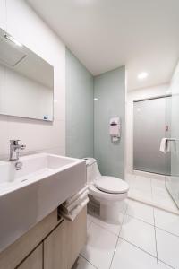 Fish Hotel - Yancheng في كاوشيونغ: حمام أبيض مع حوض ومرحاض