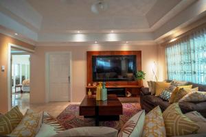 a living room with a couch and a table at Tropical Escape Villa in Ocho Rios