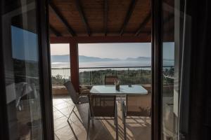 Cette chambre dispose d'un balcon avec une table et des chaises. dans l'établissement Ionion Fos, à Nikiana