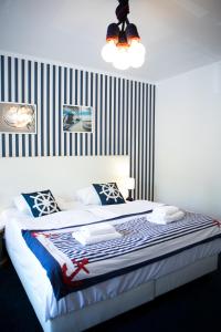 a bedroom with a large bed with a striped wall at Marina Mikołajki in Mikołajki