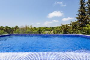 uma grande piscina com água azul num quintal em Casa dos Sonhos no Vale do Lobo