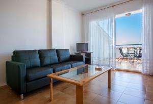 a living room with a blue couch and a coffee table at Complejo Bellavista Residencial in Pego