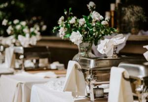 a table with white chairs and a vase of flowers at Bicentennial Inn in Buckhannon