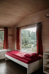a bed in a room with a large window at Atpūtas bāze ODS in Bārta