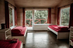 a room with two beds and a large window at Atpūtas bāze ODS in Bārta