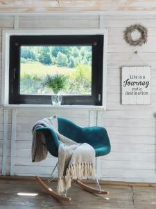 Dom z bali w Rycerce Górnej في Rycerka Górna: كرسي أخضر في غرفة مع نافذة