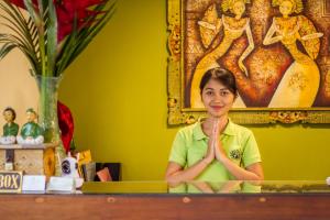 een vrouw zit in een kamer met haar handen vooraan bij Kamandhani Cottage in Ubud