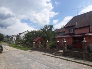 una cerca frente a una casa roja en Затишок, en Volovets