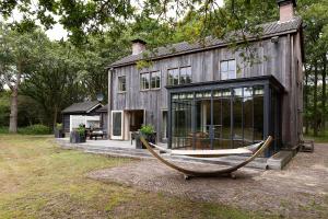 une maison avec un bateau devant elle dans l'établissement Bosvilla Kennemerduinen, à IJmuiden