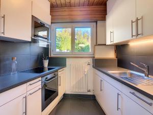 a kitchen with white cabinets and a window at Le Clavan - Studio à Crans-Montana (2-4 personnes) in Crans-Montana