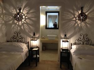 オートラントにあるMasseria Montelauroのベッドルーム1室(ベッド2台付)、バスルーム(鏡付)