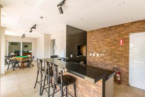 a kitchen with a black counter and a brick wall at Alegro Hotel in Jarinu