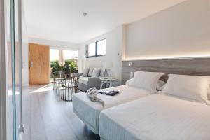 a bedroom with two beds and a living room at Apartaments Beach & Golf Resort in Pals