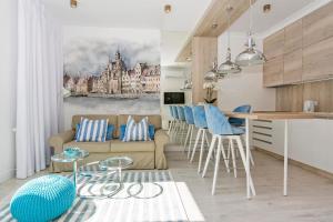 kuchnia i salon z kanapą i stołem w obiekcie Marine by OneApartments w Gdańsku +18 zdjęć