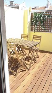 a wooden table and chairs sitting on a balcony at Modern Cosy Flat with Terrace in Campo de Ourique. in Lisbon