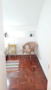 a hallway with a wicker chair and a wooden floor at Modern Cosy Flat with Terrace in Campo de Ourique. in Lisbon