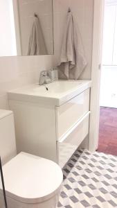 a white bathroom with a sink and a toilet at Modern Cosy Flat with Terrace in Campo de Ourique. in Lisbon