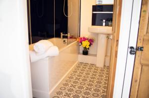 a bathroom with a toilet and a vase of flowers at Westeria Cottage in Barnstaple
