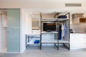 a room with white cabinets and a tv and shelves at Apartaments Beach & Golf Resort in Pals