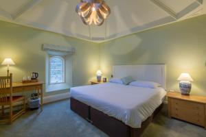 a bedroom with a bed and a desk and a chair at West Dean College in West Dean +49 photos